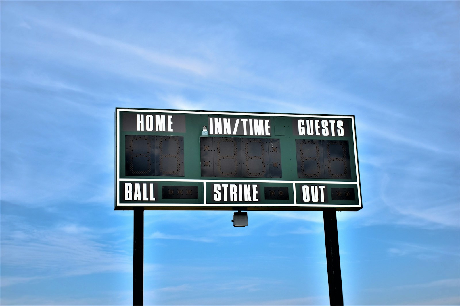 Baseball scoreboard against a beautiful sky.