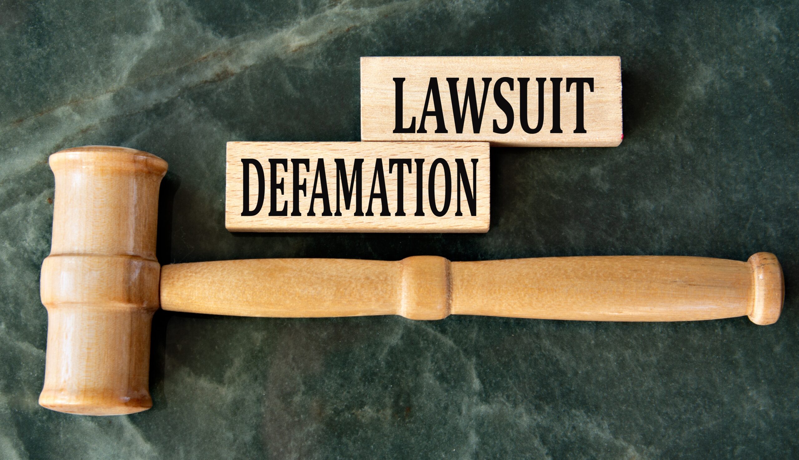 Defamation,Lawsuit,-,Words,On,Wooden,Blocks,On,A,Green